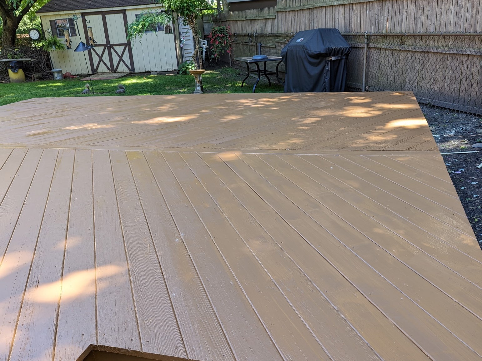 Large backyard deck with fresh wood stain finish