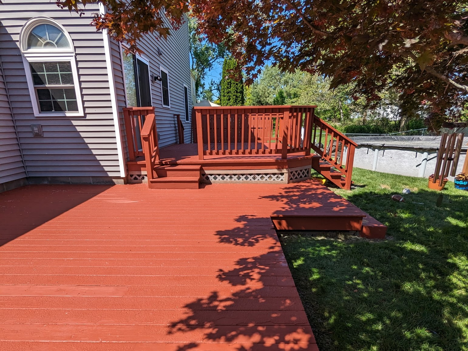 Red-stained deck and railing on gray-sided home