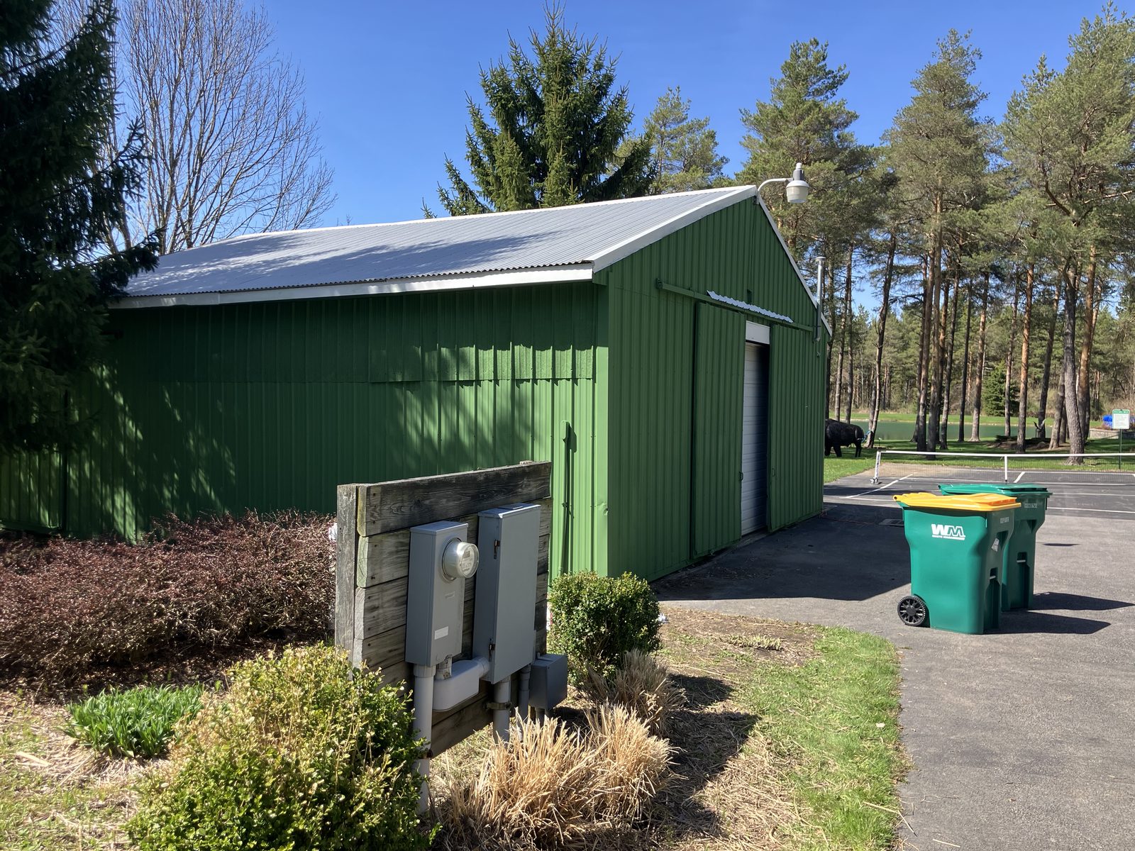 Freshly painted green metal utility building with white corrugated roof